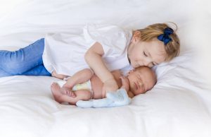 Big sister kissing little baby brother by Kika Mitchell Photography Chelmsford Newborn Photographer