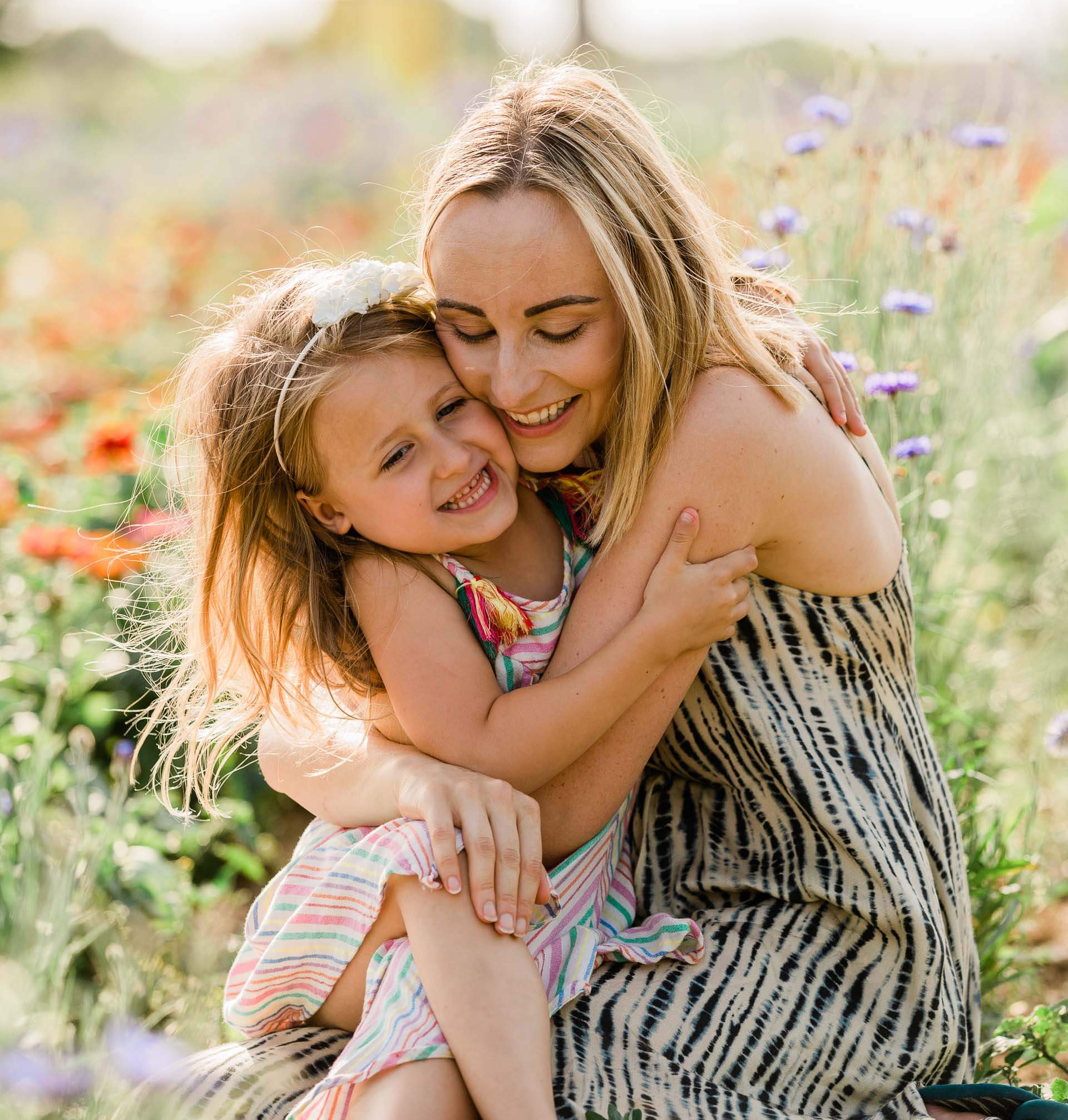 mother and daughter embrace in summer flower meadow with flowers behind captured by Chelmsford photographer Kika Mitchell Photography