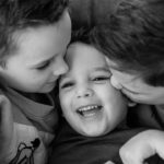 laughing kisses and cuddles in black and white image on latest family photoshoot of Emily Norris family by Chelmsford photographer Kika Mitchell Photographer