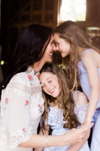 portrait of motherhood featuring mother and 2 beautiful daughter, one in middle and one getting an eskimo kiss by Chelmsford photographer Kika Mitchell photographer