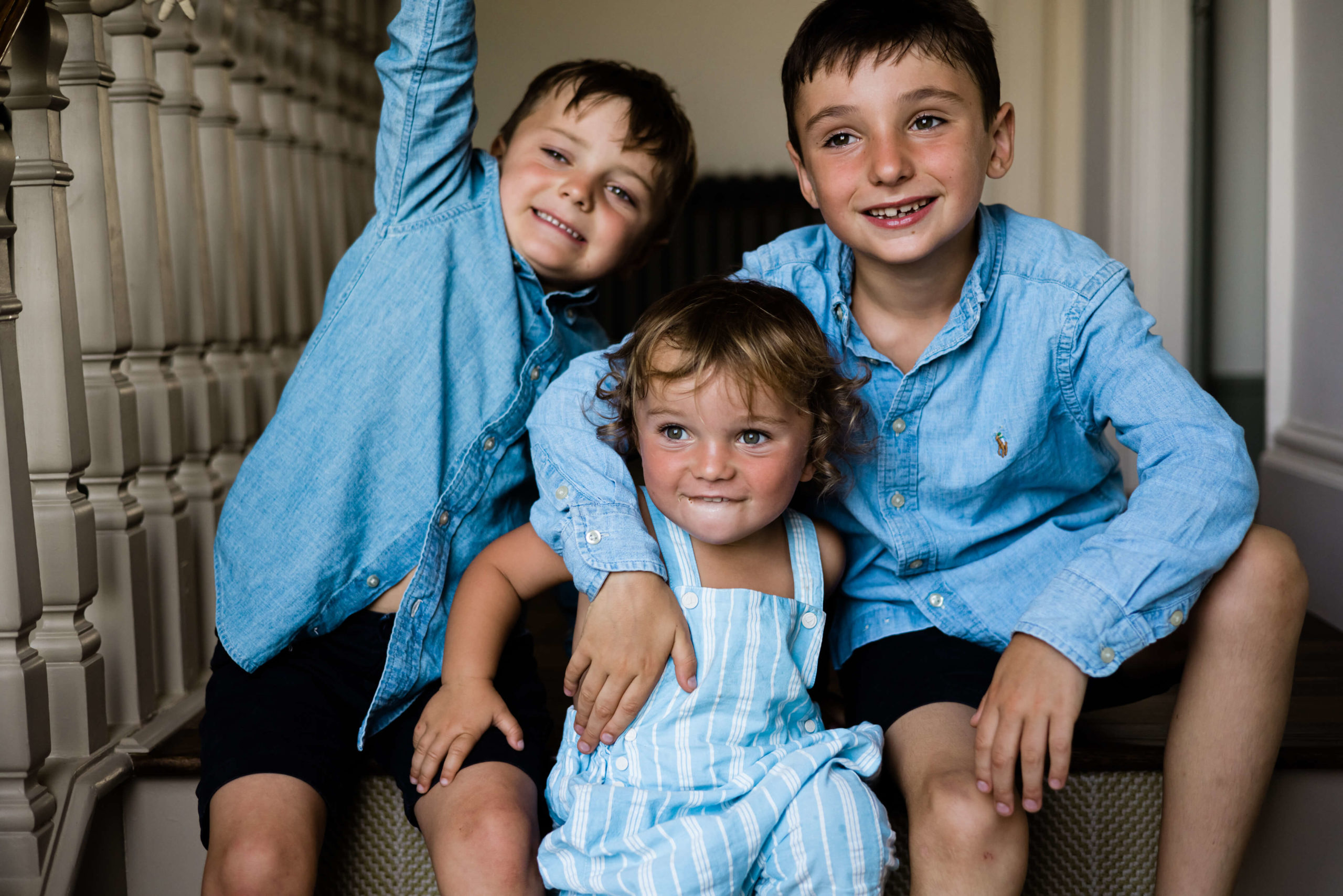 3 gorgeous brothers in blue sat on stairs captured by family photographer chelmsford Kika mitchell photographer