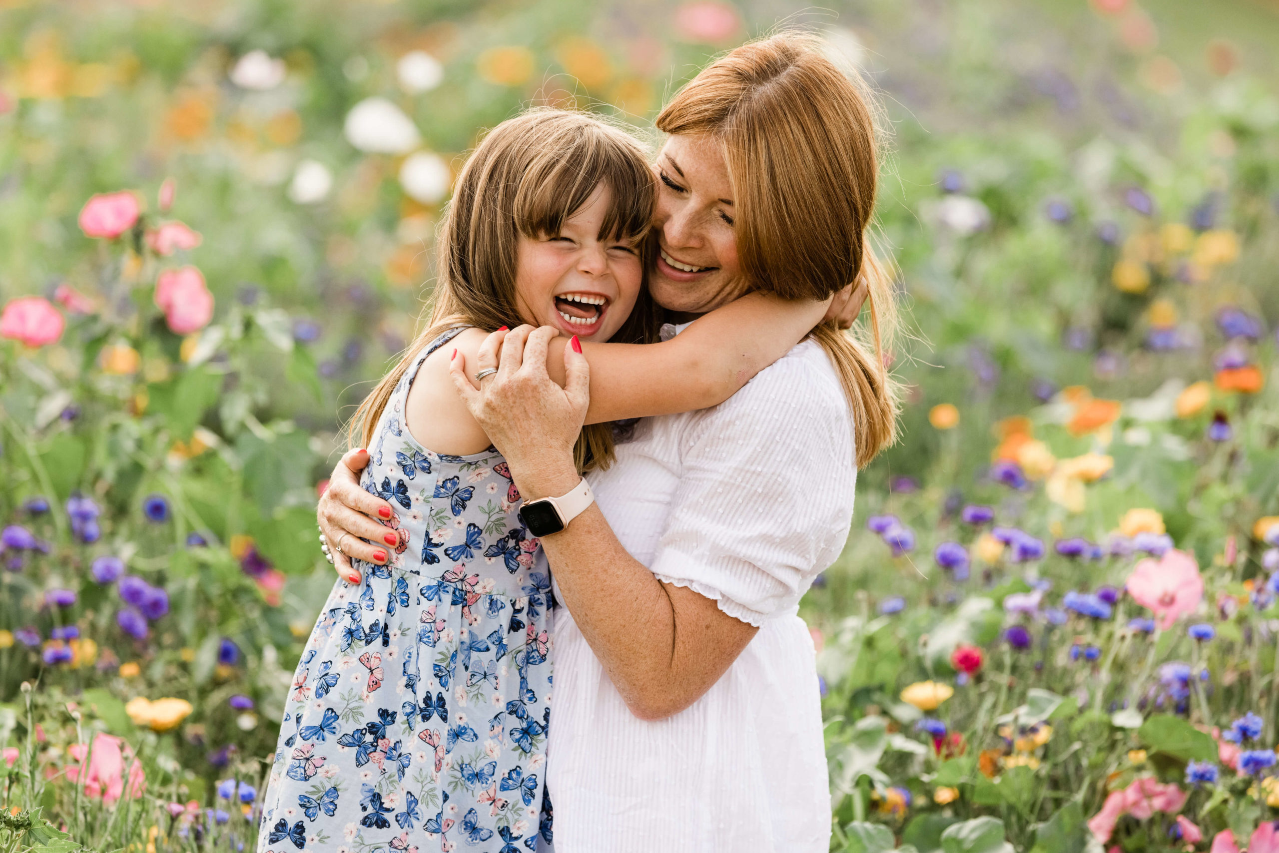 laughing girl and mother in wild flower meadow captured by Kika Mitchell Photographer family photographer Chelmsford