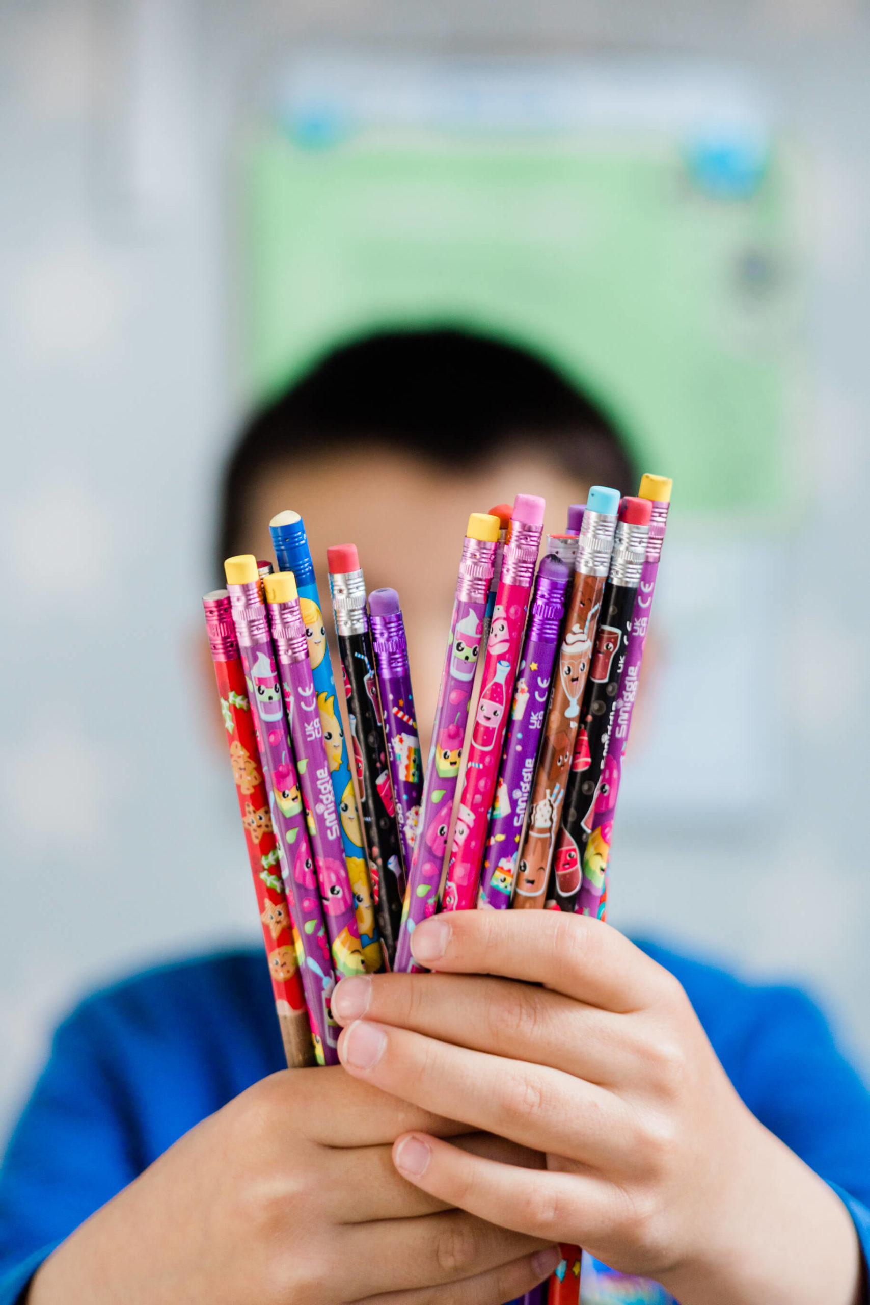 colourful smiggle pencils held up by school child